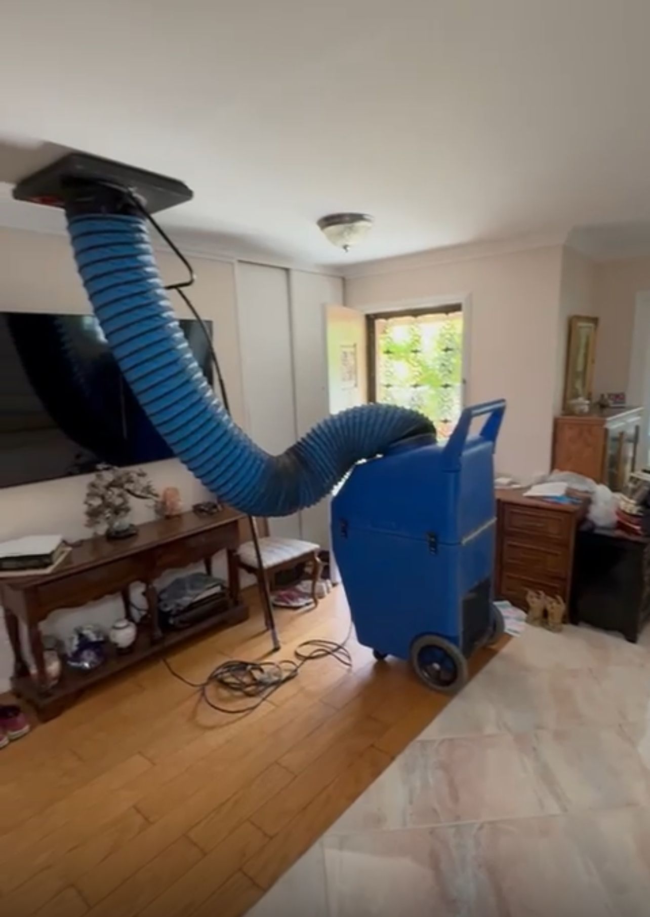 Professional air duct cleaning machine connected to home HVAC vent system