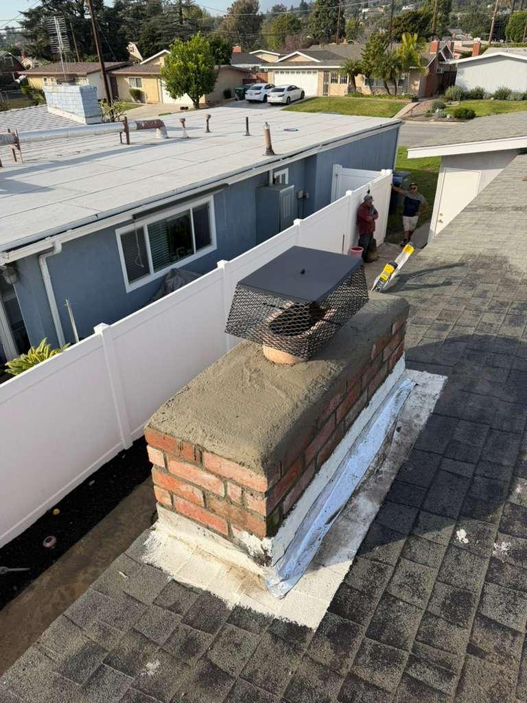 Brick chimney on residential roof inspected for cleaning and maintenance
