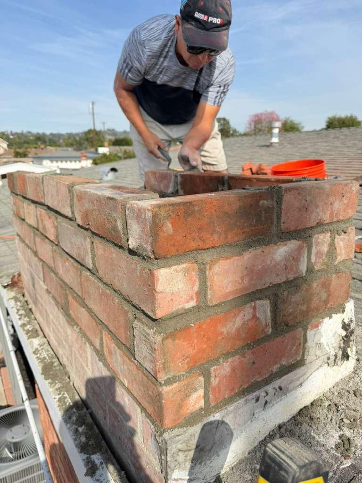 California Airduct Pros certified mason laying brick course by course during professional California chimney construction