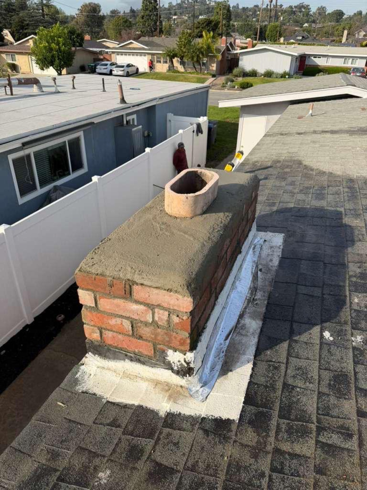 Newly poured concrete crown on top of restored California chimney — sloped to shed rainwater away from the masonry below