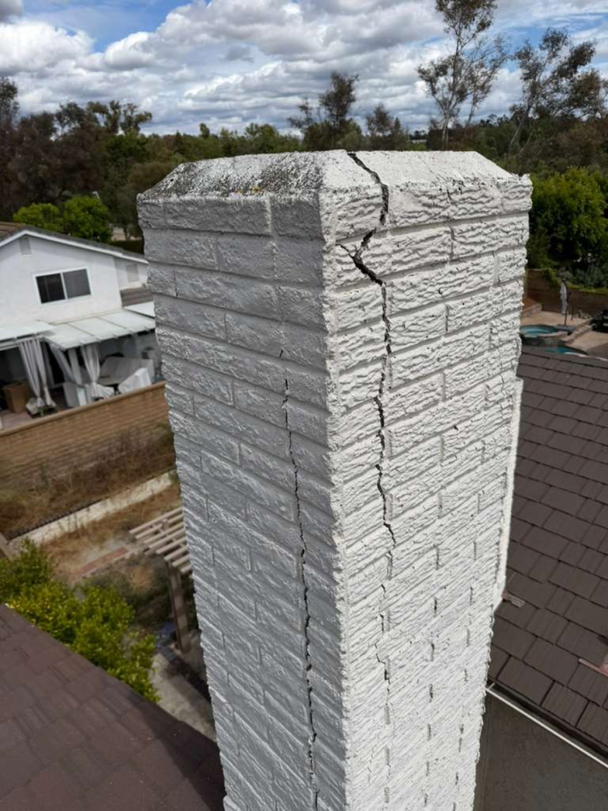 California chimney with major vertical crack along the corner before professional repair by California Airduct Pros — masonry damage requiring tuckpointing and crown restoration