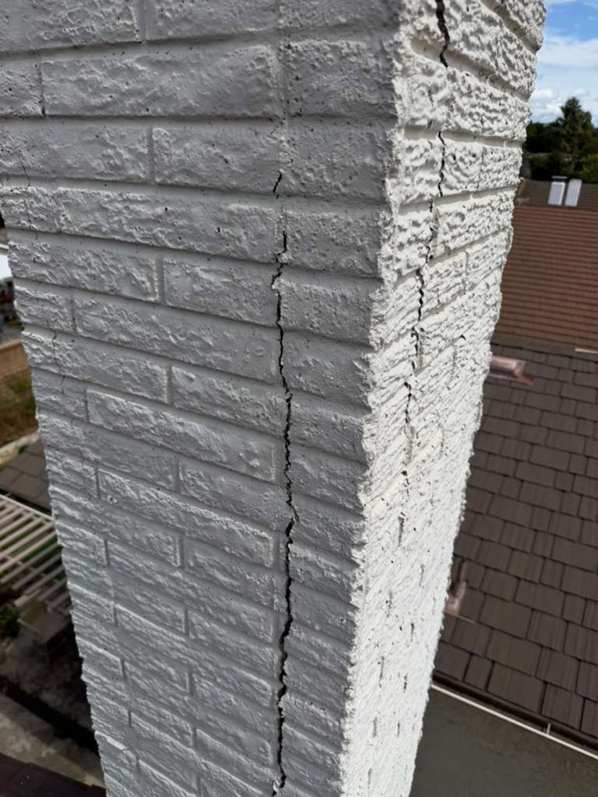 Close-up of deep vertical crack in California chimney mortar joint before professional repair — water intrusion damage typical of California weathering