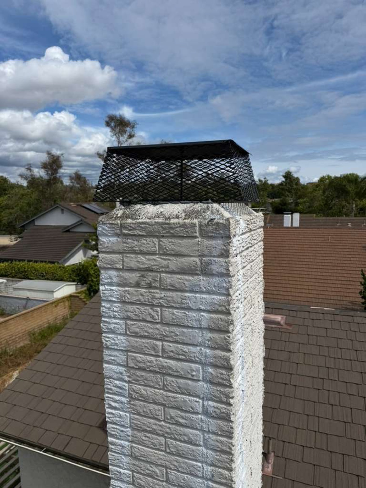 New stainless steel mesh cap installed atop repaired California chimney by California Airduct Pros — blocks rain, birds, embers, and debris