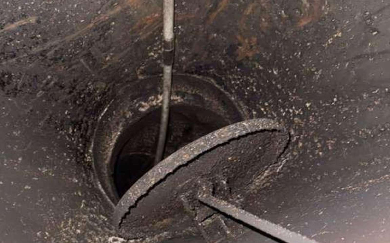 California Airduct Pros rotary brush working through California dryer vent — mechanical agitation dislodging compacted lint at every bend