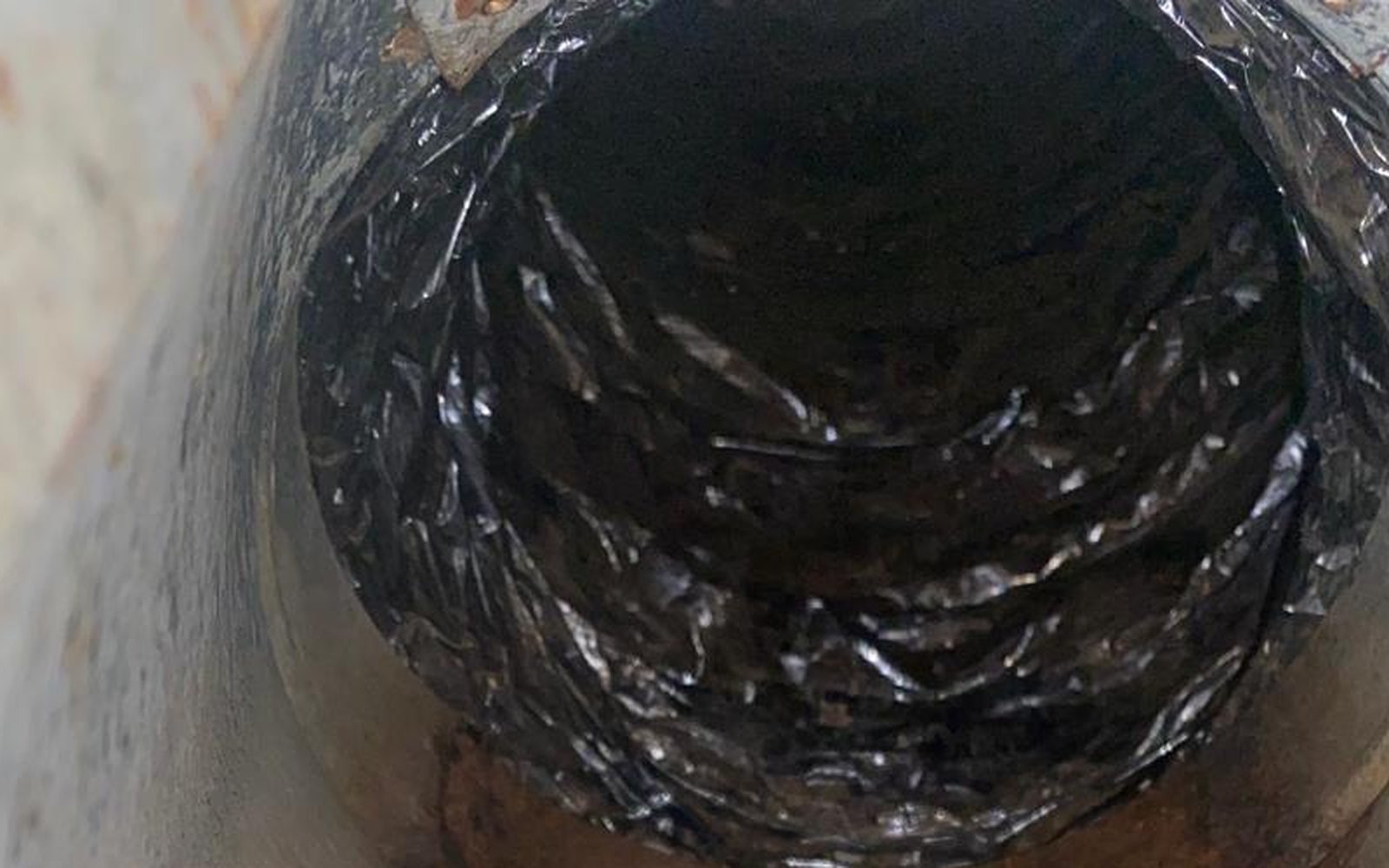 Interior view of California dryer vent showing buildup and oxidation during professional inspection by California Airduct Pros — documented before/after for every customer